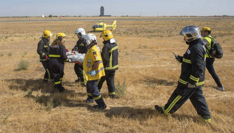 efectivos del sescam y bomberos ciudad real trasladando a uno de los figurantes del simulacro del aeropuerto